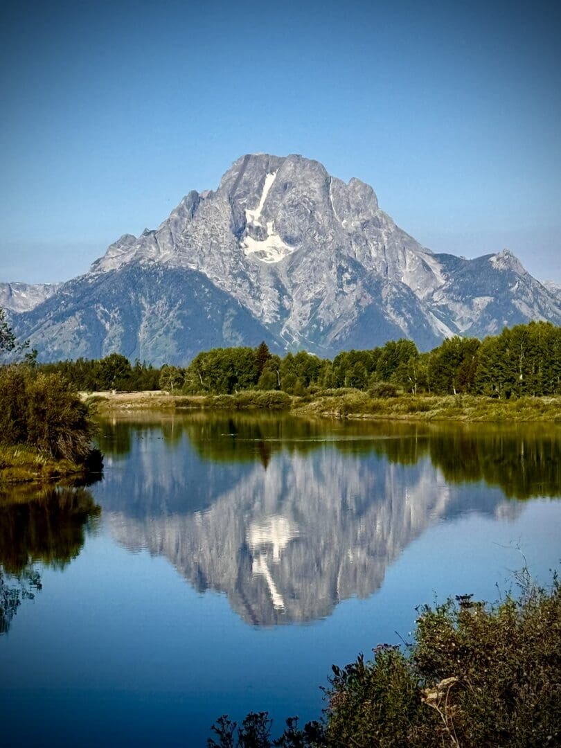 Mountain reflected in calm lake with trees