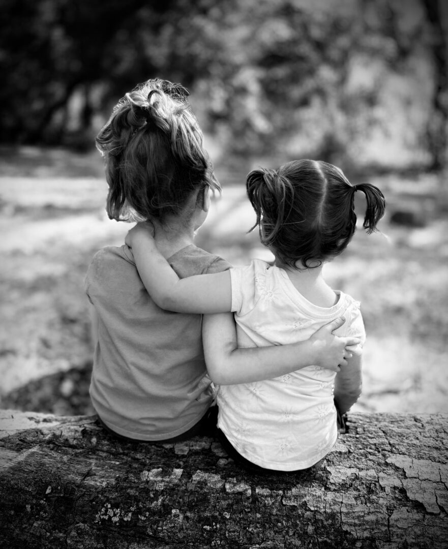 Two children embrace, viewed from behind