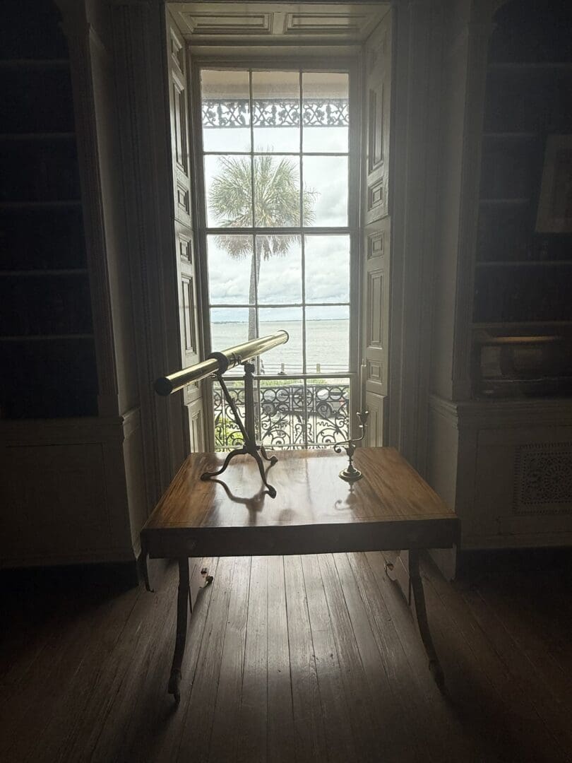 Antique brass telescope facing seafront window