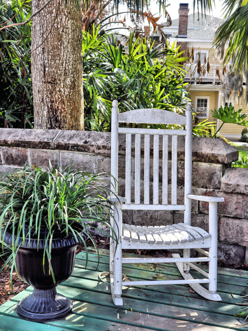 White rocking chair beside potted plant