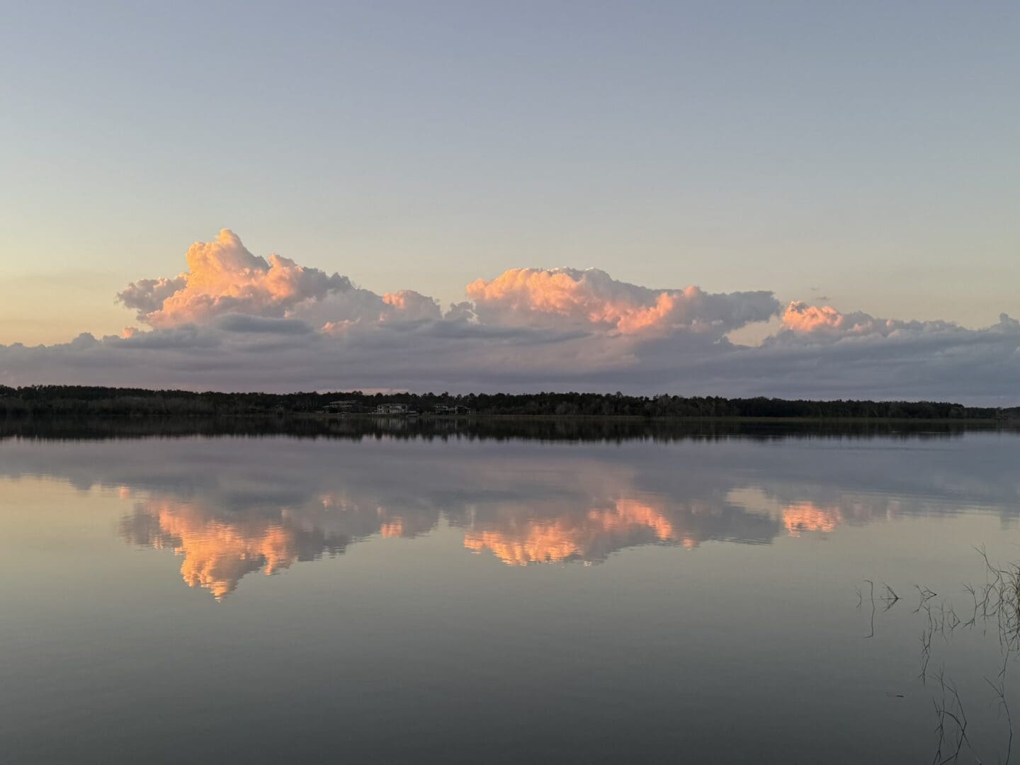 Sunset cumulus clouds mirrored across water